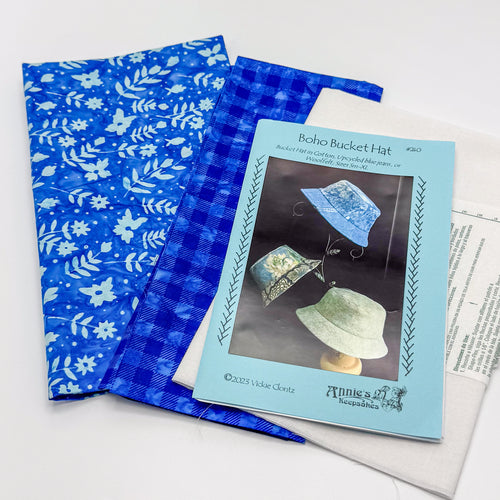 Blue patterned fabric with a sewing pattern featuring a boho bucket hat design.