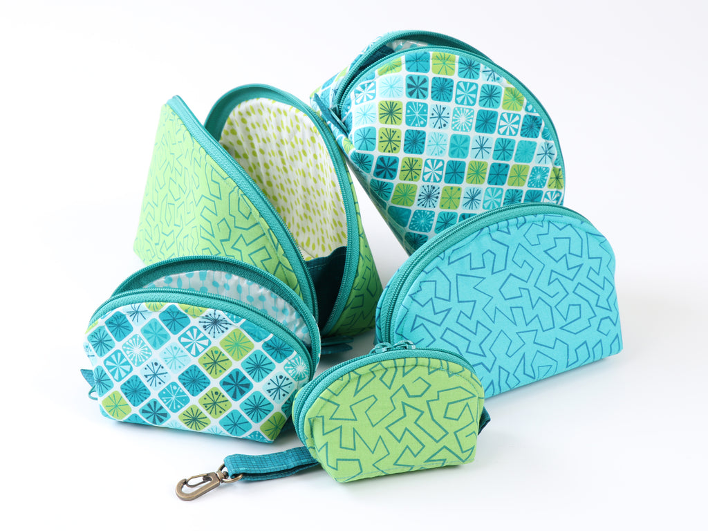 Set of green and blue patterned zippered pouches on a white background