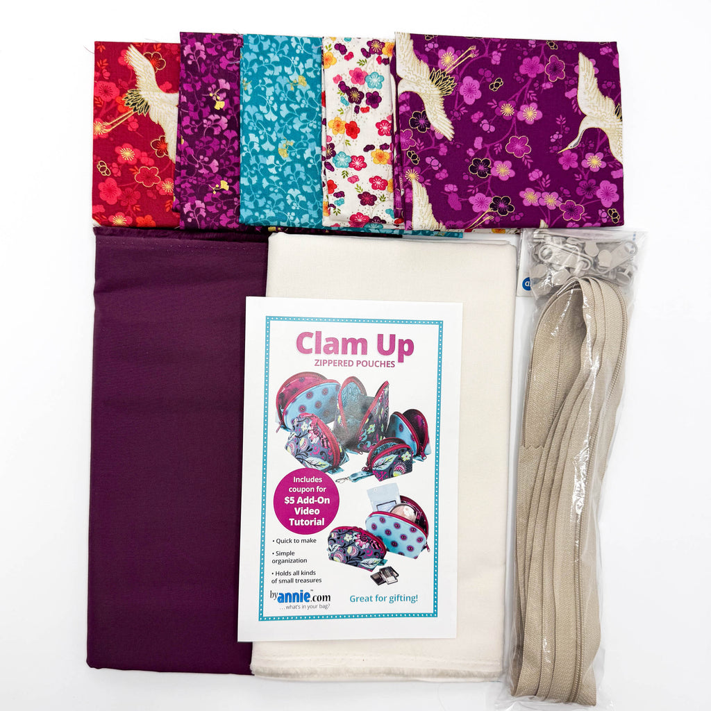 Fabric bundle with colorful patterns, a zipper, and a 'Clam Up' pouch sewing pattern on a white background