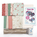 Collection of fat quarters with floral patterns, a zipper, and a 'Clam Up' sewing pattern on a white background.