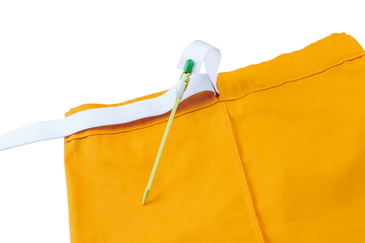Close-up of a yellow garment with a white piece of elastic attached to a green Clover bodkin on a white background
