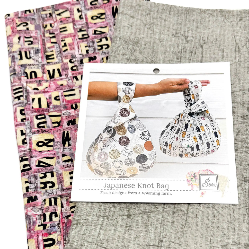 Japanese Knot Bag sewing pattern with two patterned fabrics on a textured surface