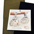 Japanese Knot Bag sewing pattern and two patterned fabrics on a white background