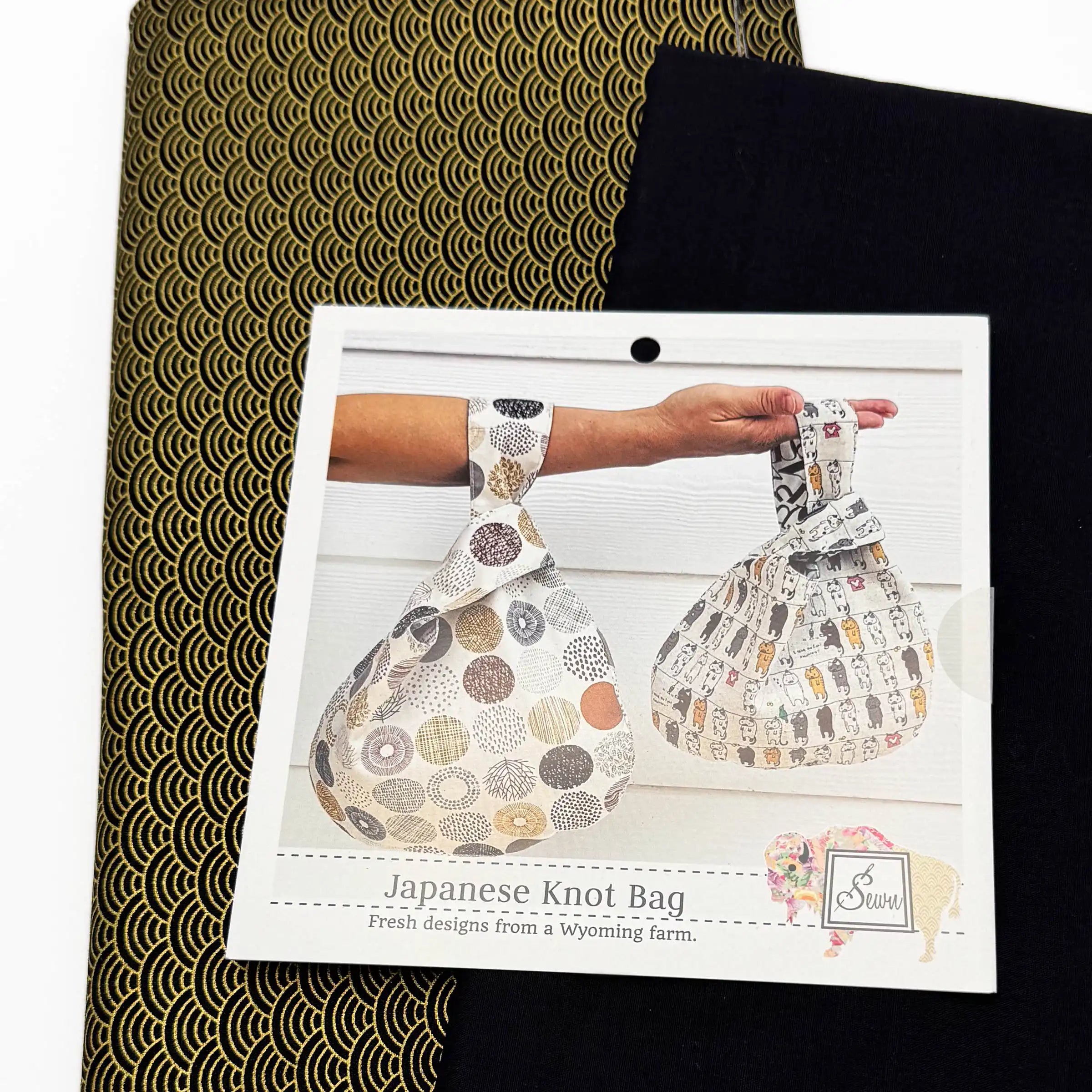 Japanese Knot Bag sewing pattern and two patterned fabrics on a white background
