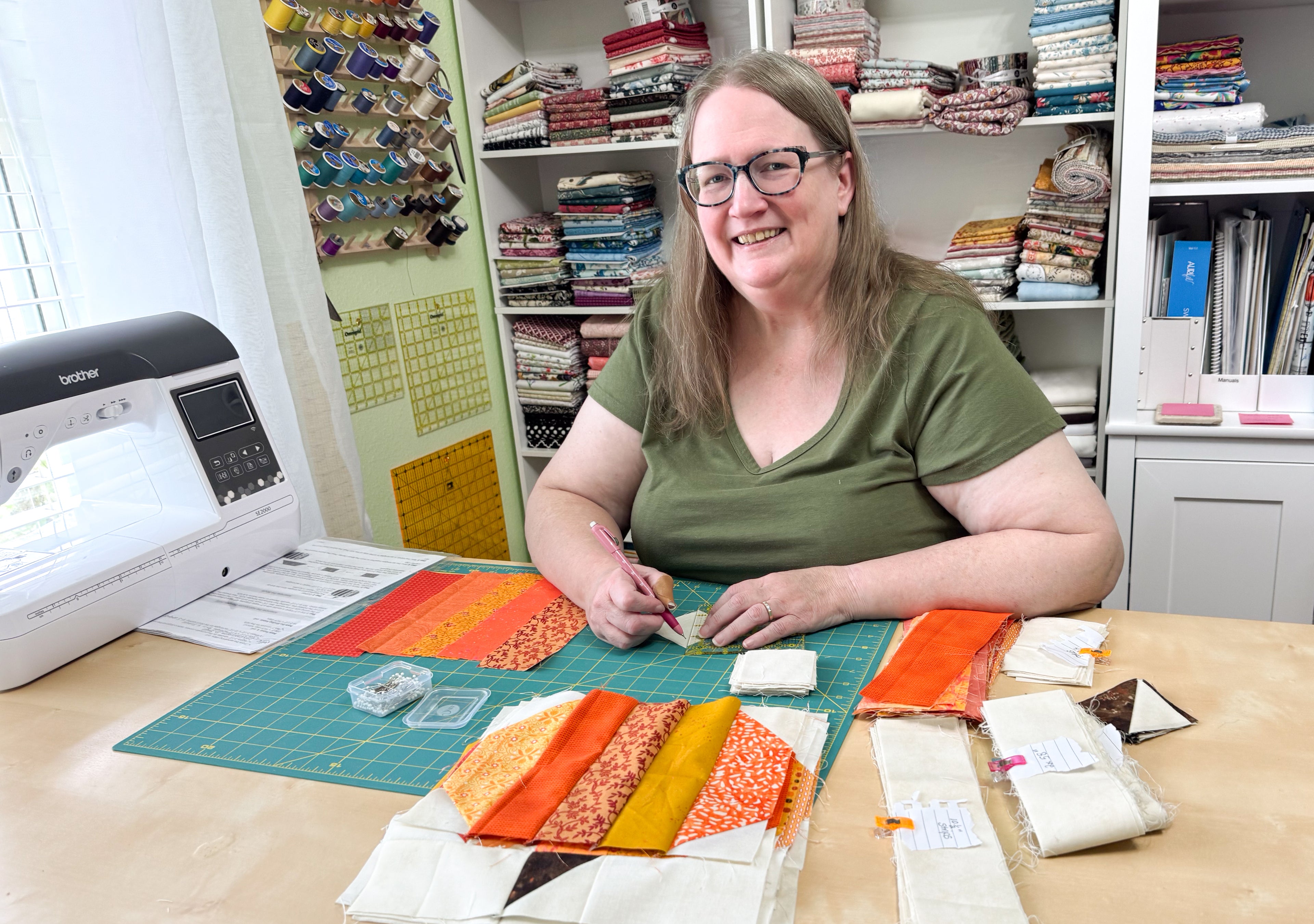 Woman in a craft room with sewing materials and a sewing machine.