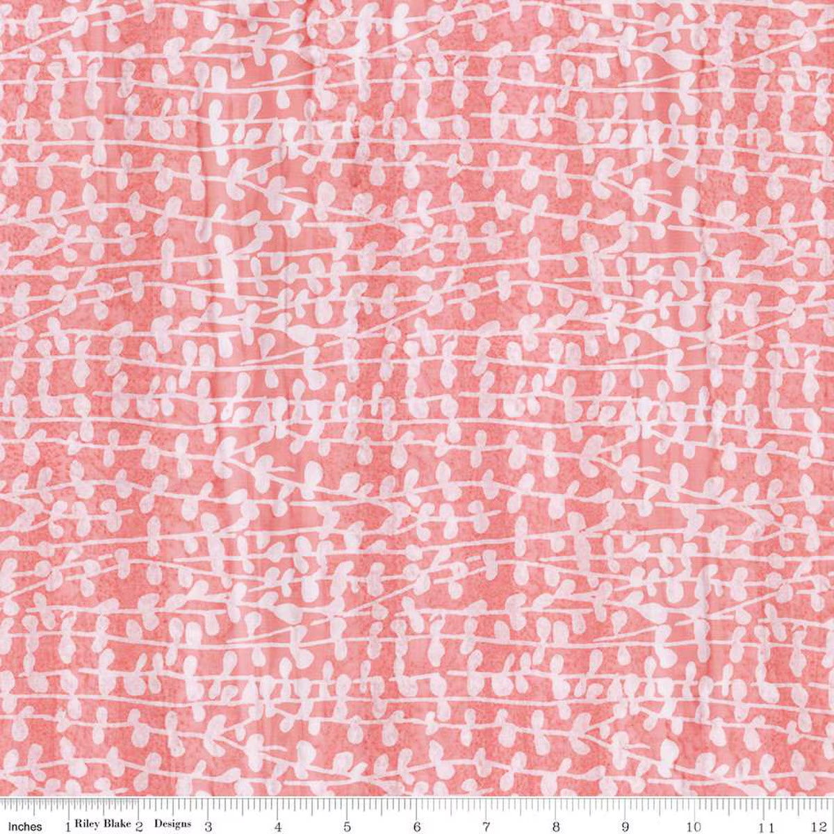 Pink batik fabric with white stem and leaf pattern, featuring a ruler at the bottom for scale.