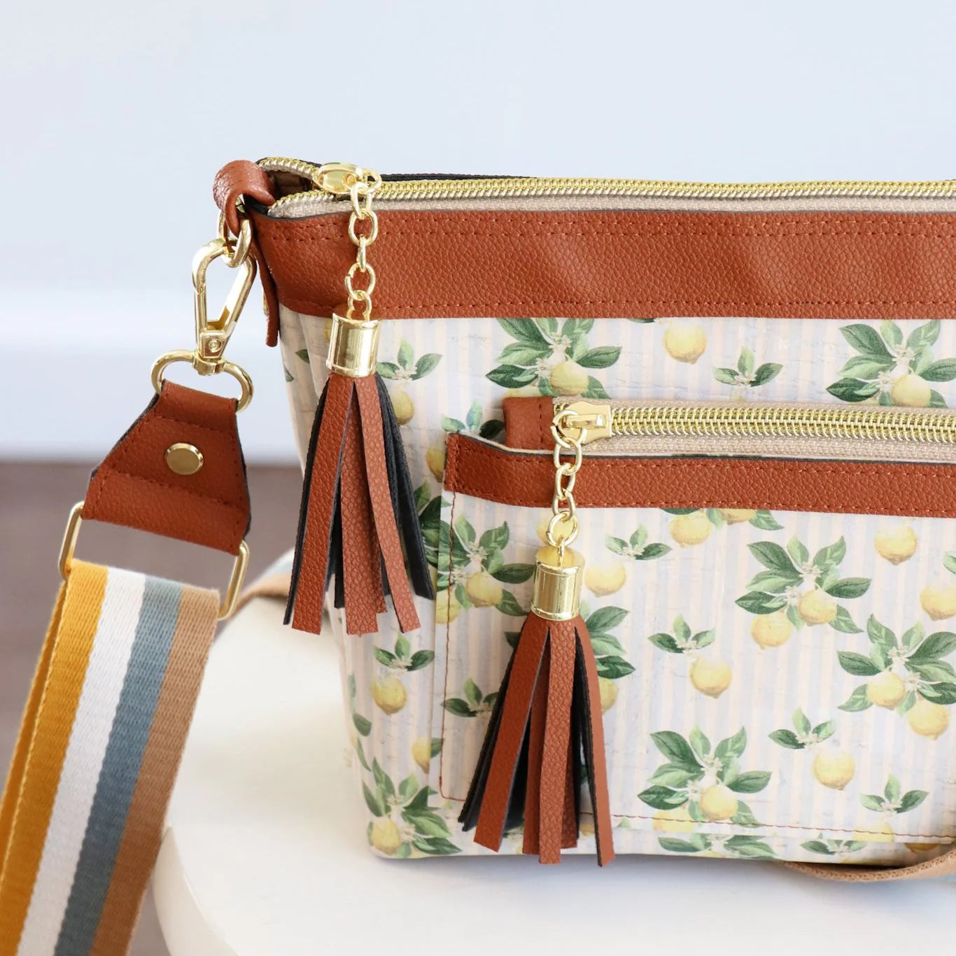 Handbag with lemon pattern and tassel details on a light background
