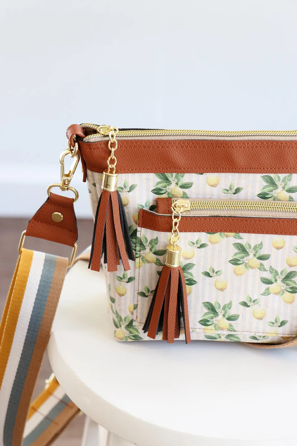 Handbag with floral pattern and tassels on a white surface