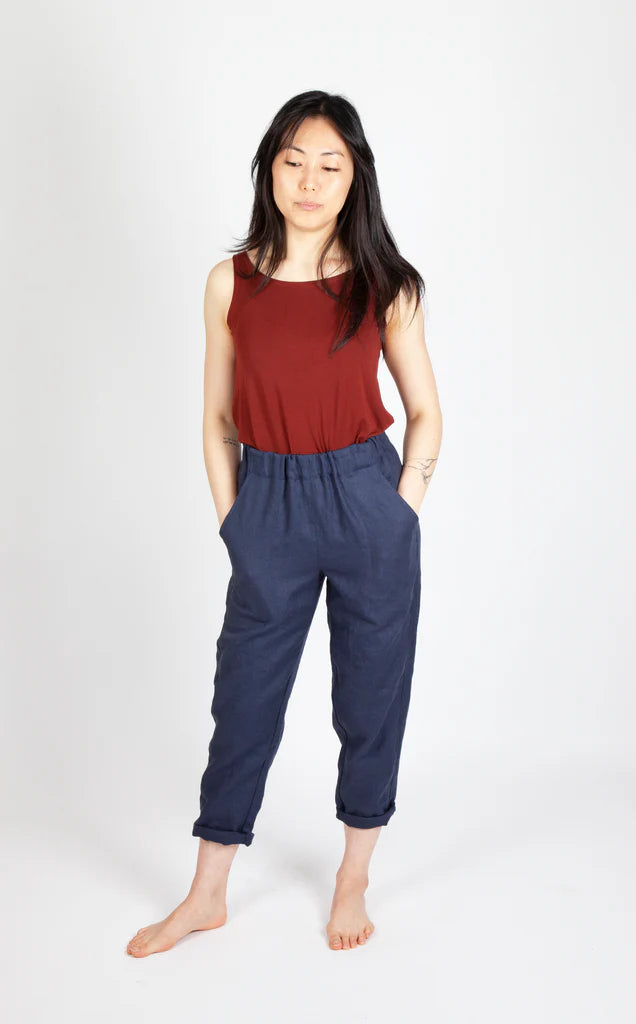 Woman wearing a red sleeveless top and navy Free Range Slacks on a white background