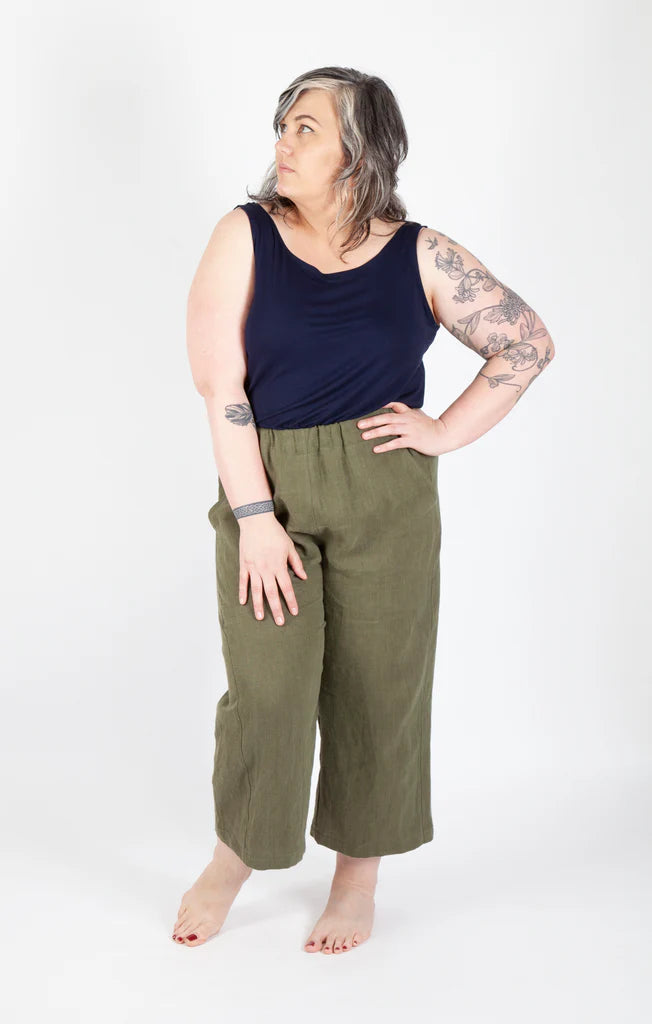 Person wearing a navy tank top and olive green Free Range Slacks on a white background