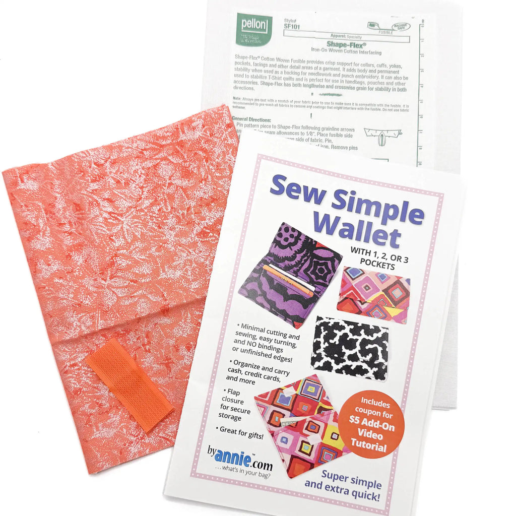 Fabric wallet kit with orange sparkly fabric, interfacing, and sewing instructions on a white background