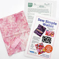 Sew Simple Wallet kit with pink patterned fabric, sewing pattern, interfacting and hook and loop tape on a white background