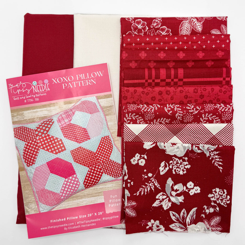 Red fabric with patterns and a pink pillow pattern book on a white background


